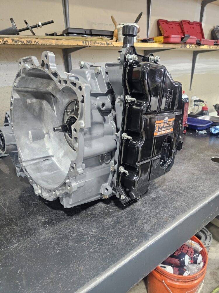 Professional technician at Top Notch Transmissions performing a precision transmission rebuild on a workbench, ensuring long-term reliability for a customer's vehicle.